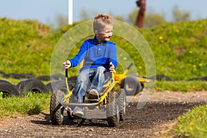 Boy maneuvering pedal go cart