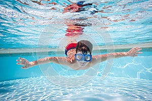 Boy in mask dive in swimming pool