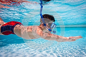 Boy in mask dive in swimming pool