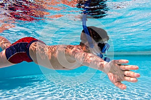 Boy in mask dive in swimming pool