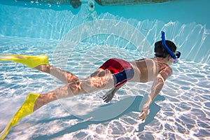 Boy in mask dive in swimming pool