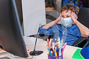 Boy with mask on his face is tired distance learning during quarantine covid-19