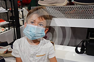 A boy with mask on the shopping centre. Coronavirus mask infection prevention. Coronavirus pandemic, epidemic disease