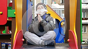 A boy in a medical bandage sits in a lotus position