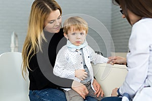 Boy in medicine healthcare mask. Portrait of mother and child at a doctor`s appointment.