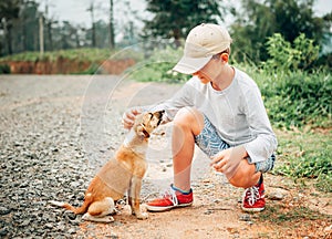 Boy met a little homeless puppy on the street