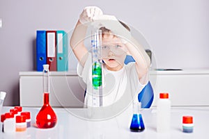 Boy mixing colored liquids in test tubes