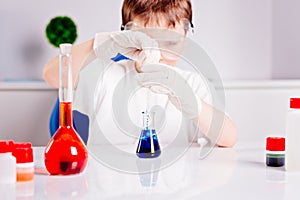 Boy mixing colored liquids in test tubes