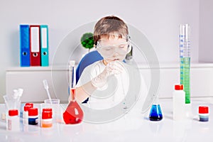 Boy mixing colored liquids in test tubes