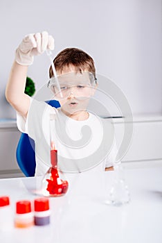Boy mixing colored liquids in test tubes