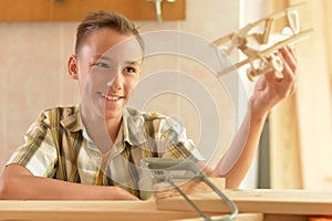 Boy with model of plane and handsaw