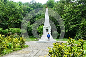 A boy at the monument of the Iver Chapel in the Dante Gorge in the resort park. Hot Key. Russia 2021