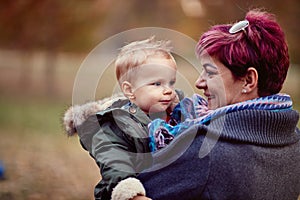 Boy with mother at the autumn park. Family, childhood, season and people concept