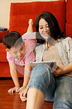 Boy and mother playing games with tablet