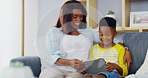 Boy, mother and smile with tablet on sofa to play video games, watch movies and elearning app for kids at home. Mom