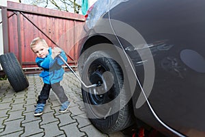 Boy mounted tires on a car.