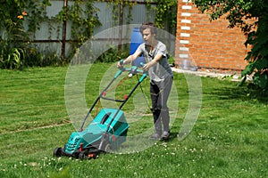 Boy mowing the lawn with lawnmower