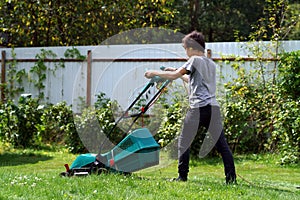 Boy mowing the lawn with lawnmower