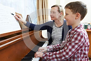 Boy With Music Teacher Having Lesson At Piano photo