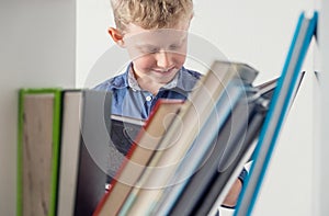 Boy near bookshelf read interesting book