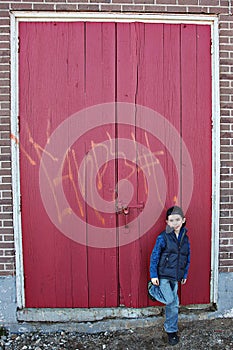 Boy near red wooden door