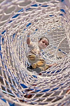 Boy in net sleeve of amusement park climbing facility