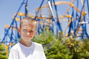 Boy next to a roller coaster