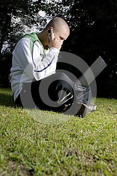 Boy with notebook and cell phone in park