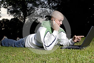 Boy with notebook and cell phone in park