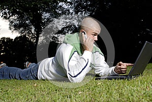 Boy with notebook and cell phone in park