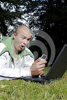 Boy with notebook and cell phone in park