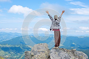 Boy with open arms stands on the cliff