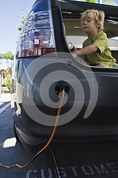 Boy In Open Car Trunk At Gas Station