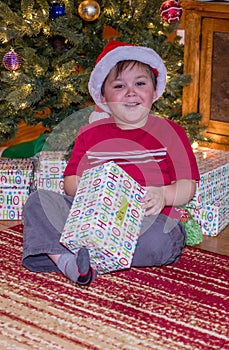 Boy opening Christmas presents at Christmas time