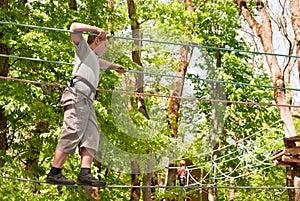 A boy overcomes obstacles, walking on a rope photo