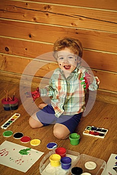 Boy painter painting on wooden floor