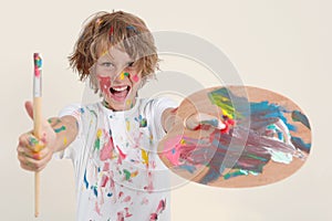 Boy painting with brush and pallete