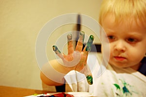 Boy paints with fingers