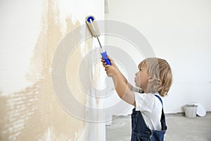 Boy paints the wall roller