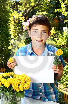boy with paper sheet on the summer garden background