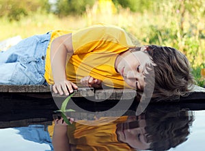 Boy in park play with boat in river