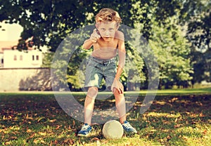 Boy in park ready to kick ball