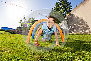 Boy pass under course of barriers on his fours