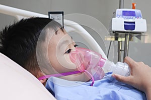 Boy patient with asthma allergy using the asthma inhaler.Inhaler mask for treatment in hospital.Health asthmatic in hospital. photo