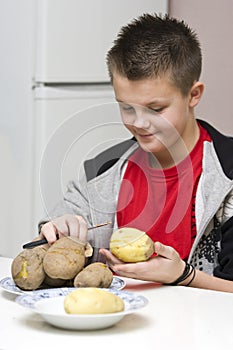 Boy peeling potatoes