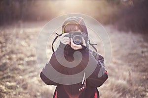 Boy photographer holding camera his face covered in winter nature
