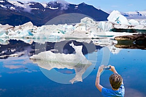 Boy photographs ice floes with smartphone