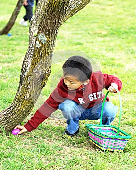 A boy picks up Easter eggs