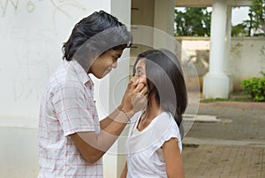 Boy pinching girl's cheeks