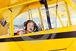 Boy in Piper Cub airplane wearing headset photo